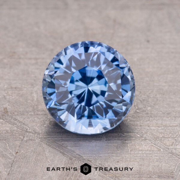 1.62-Carat Ceylon Sapphire A 1.62-carat Ceylon Sapphire, round and faceted, is showcased on a textured surface.