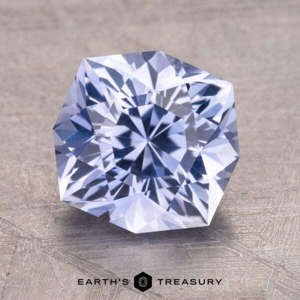 3.05-Carat Ceylon Sapphire 3.05-Carat Ceylon Sapphire, a faceted gemstone with a hexagonal shape on a textured surface. Text reads "Earth's Treasury" below.