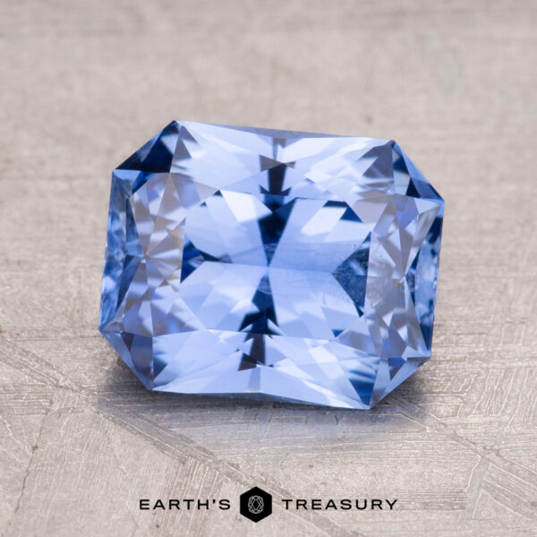 2.68-Carat Ceylon Sapphire A 2.68-carat Ceylon Sapphire, with complex facets and a sparkling blue hue, rests on a textured surface.