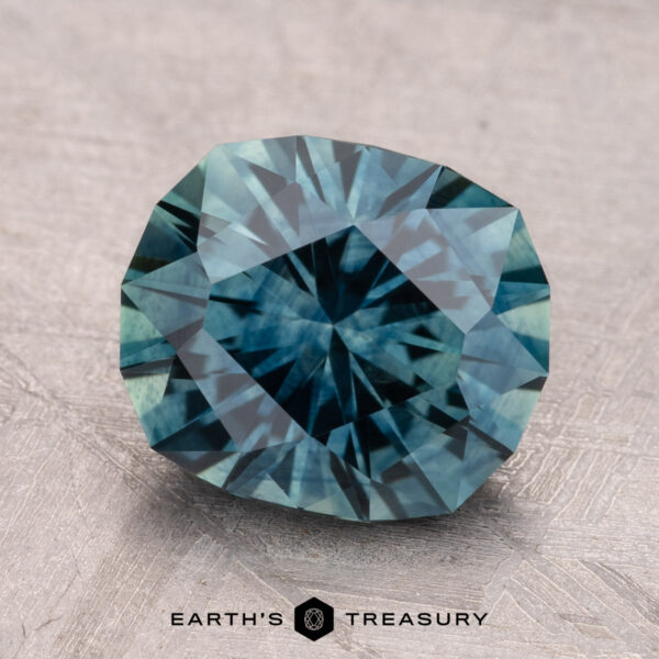 3.35-Carat Montana Sapphire (Heated) A 3.35-carat heated Montana sapphire gemstone, shown against a textured background, is labeled "Earth's Treasury" in the corner.