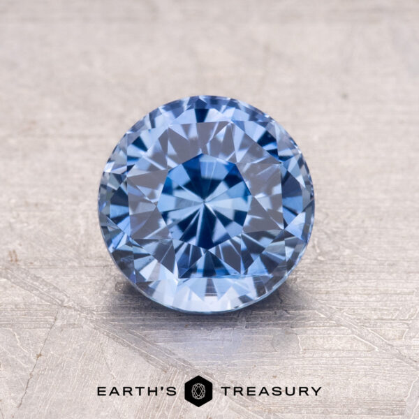 1.62-Carat Ceylon Sapphire A 1.62-carat Ceylon Sapphire, round and faceted, is showcased on a textured surface.