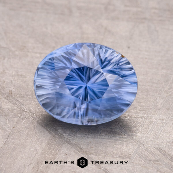 3.10-Carat Madagascar Sapphire A 3.10-carat Madagascar Sapphire with intricate cuts is set against a plain background. The text "Earth's Treasury" appears at the bottom.