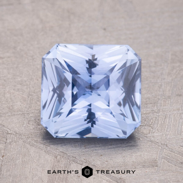 2.13-Carat Ceylon Sapphire A 2.13-carat Ceylon Sapphire, featuring a light blue square cut and intricate facets, is positioned on a textured surface.