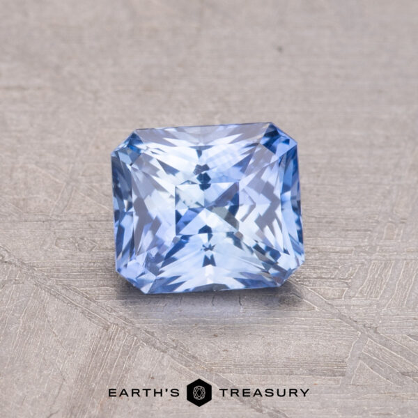 1.02-Carat Ceylon Sapphire A 1.02-carat square-cut Ceylon Sapphire with intricate facets rests on a textured surface, labeled "Earth's Treasury" below.