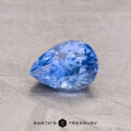 A 1.09-carat Ceylon sapphire rests on a textured gray surface.