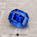 A 1.93-Carat Royal Blue Ceylon Sapphire with a rectangular shape and multiple facets rests on a textured surface.