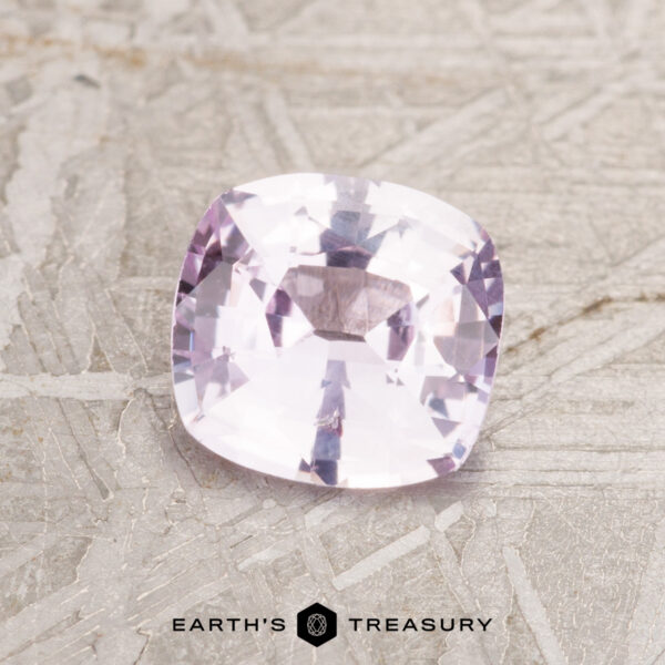 1.07-Carat Light Pink Ceylon Sapphire A 1.07-carat light pink Ceylon sapphire cushion-cut gemstone displayed on a textured surface with "Earth's Treasury" beneath.