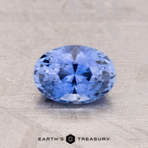 Oval-cut 1.33-Carat Ceylon Sapphire displayed on a textured surface, with "Earth's Treasury" logo below.