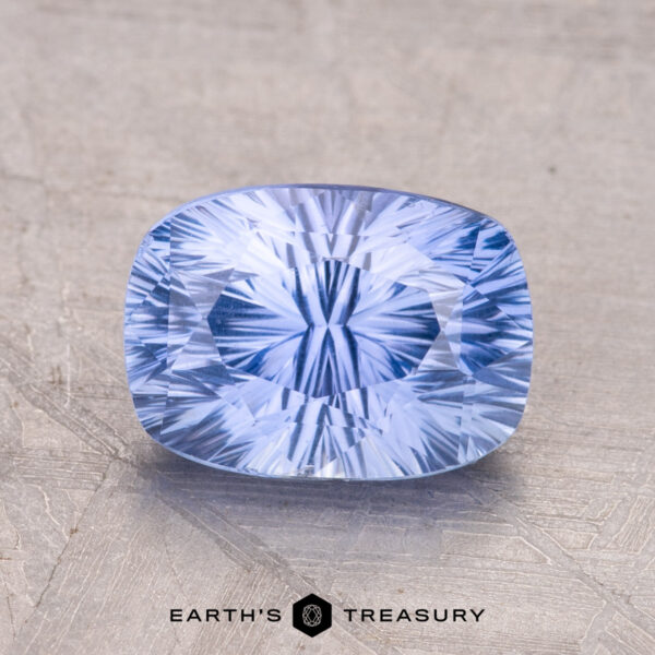 A 2.67-carat Ceylon Sapphire with internal patterns rests on a textured surface, with "Earth's Treasury" below.