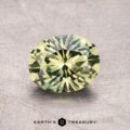 A round brilliant cut green gemstone on a textured surface, with the text "1.43-Carat Australian Sapphire (Heated)" below it.