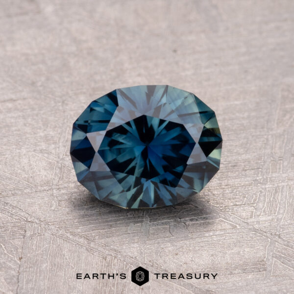 1.29-Carat Australian Sapphire (Heated) A 1.29-carat round-cut Australian sapphire (heated) displayed on a textured surface.