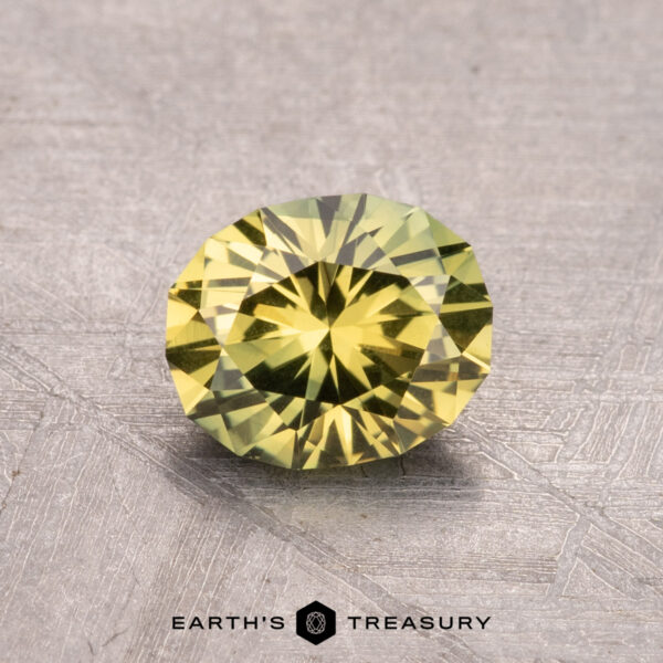 1.25-Carat Australian Sapphire (Heated) 1.25-carat Australian sapphire (heated), round-cut, yellow gemstone on a textured surface.