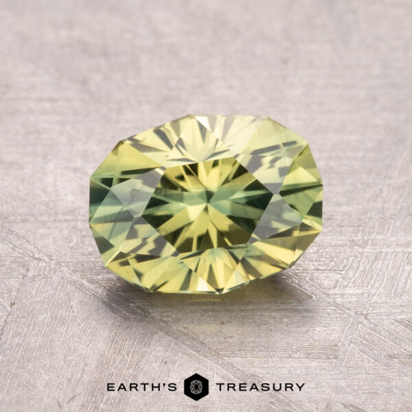 1.82-Carat Australian Sapphire (Heated) A 1.82-carat Australian sapphire (heated) with a yellow-green hue, displayed on a light textured surface.