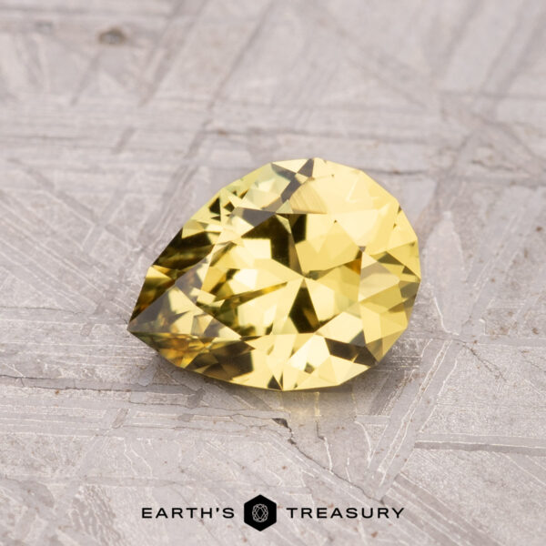 1.22-Carat Australian Sapphire (Heated) A 1.22-carat Australian yellow pear-shaped heated sapphire set on a textured surface.