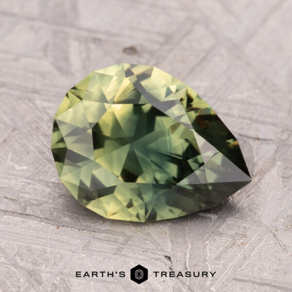 2.49-Carat Australian Sapphire (Heated) A pear-shaped, green gemstone with facets on a textured surface, labeled "2.49-Carat Australian Sapphire (Heated)".