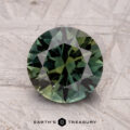 A 2.57-carat Australian sapphire (heated), with round green facets, is placed on a textured gray surface labeled "Earth's Treasury" at the bottom.