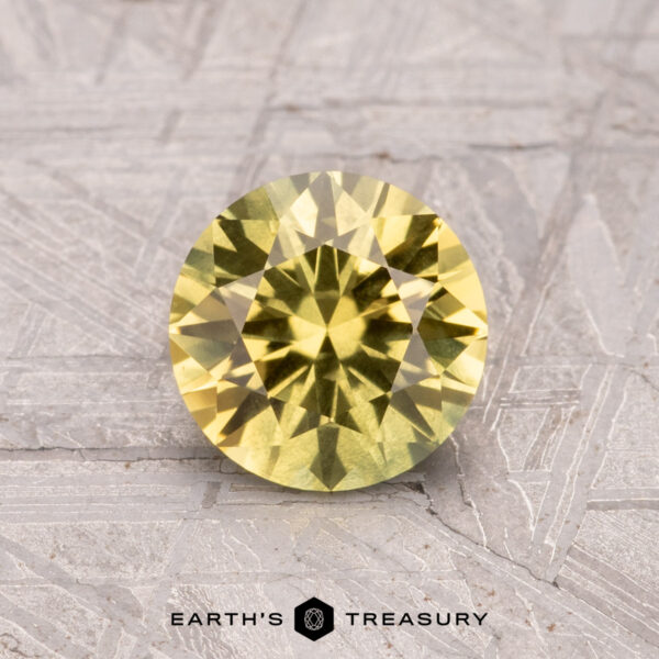 1.26-Carat Australian Sapphire (Heated) A 1.26-carat Australian sapphire (heated) sits on a textured gray surface, with the "Earth's Treasury" logo at the bottom.