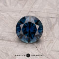 1.01-carat Australian sapphire (heated) set against a textured gray surface.