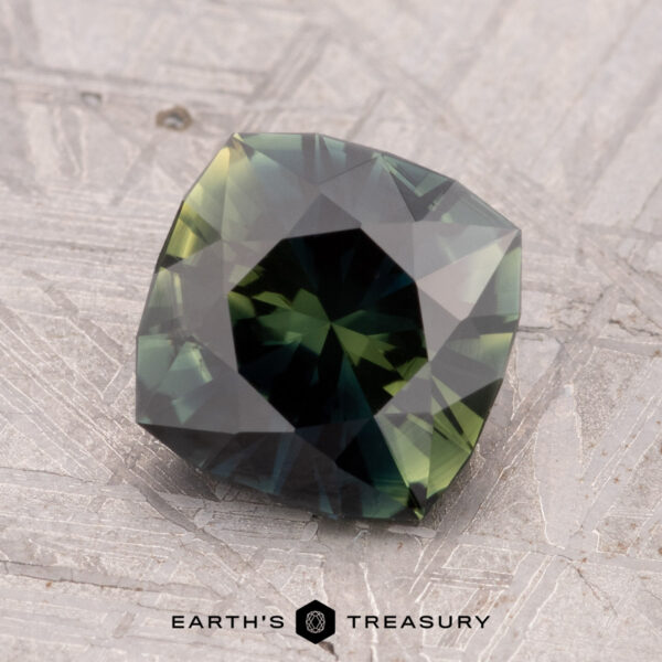 2.12-Carat Australian Sapphire (Heated) A 2.12-carat heated Australian sapphire with a faceted square shape and checkerboard pattern set on a textured gray surface.