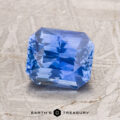 A 2.17-carat Cornflower Blue Ceylon Sapphire with an octagonal shape is displayed on a textured beige surface, with the Earth’s Treasury logo visible below.