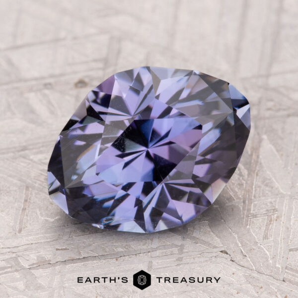 A faceted tanzanite gemstone, weighing 4.05 carats, rests on a textured surface with the "Earth's Treasury" logo beneath it.