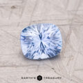 A faceted light blue 1.25-Carat Ceylon Sapphire sits on a textured surface, featuring the "Earth's Treasury" logo at the bottom.