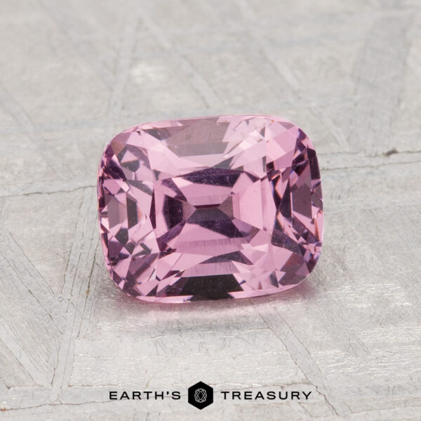 1.68-Carat Spinel A 1.68-carat cushion-cut pink spinel is displayed on a textured gray surface with the text "Earth's Treasury" below.