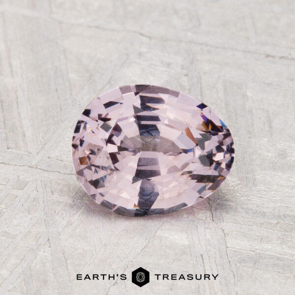 1.30-Carat Spinel A 1.30-carat faceted oval light pink spinel is displayed on a textured gray surface, with "EARTH'S TREASURY" shown below.