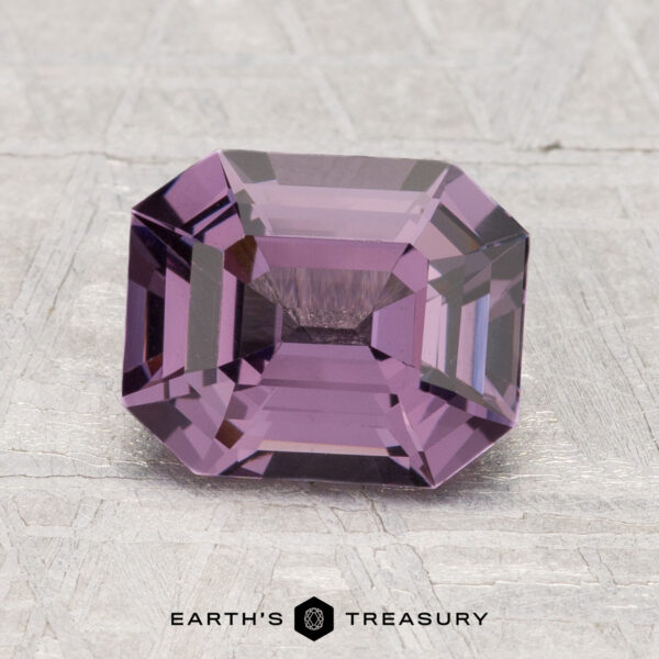 2.12-Carat Spinel A rectangular, emerald-cut 2.12-carat Spinel gemstone in purple is shown on a light textured surface with "EARTH'S TREASURY" branding below.