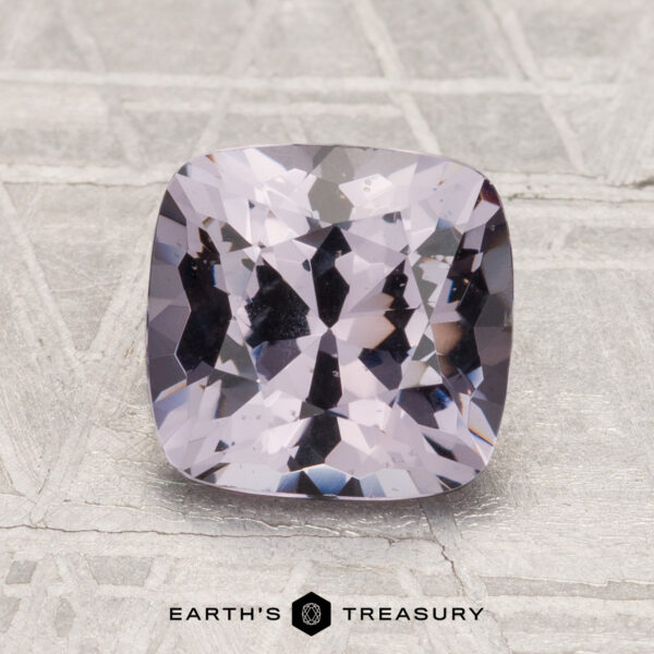 2.04-Carat Spinel A 2.04-carat, cushion-cut spinel in light purple is displayed on a textured gray background with the text "EARTH'S TREASURY" below.