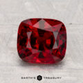 A 2.74-carat cushion-cut red Spinel is showcased on a light gray textured surface, with the text "EARTH'S TREASURY" at the bottom.