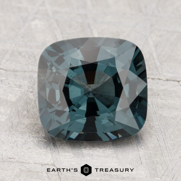 2.54-Carat Spinel A 2.54-carat spinel gemstone is displayed on a textured light gray surface with the "Earth's Treasury" logo below.