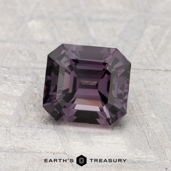 1.53-Carat Spinel A 1.53-carat, square-cut deep purple Spinel displayed on a textured light grey surface with "EARTH'S TREASURY" at the bottom.