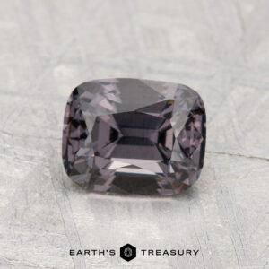 A 1.64-carat faceted rectangular Spinel with a dark, muted purple hue is displayed on a light, textured surface; the "Earth's Treasury" logo appears at the bottom.