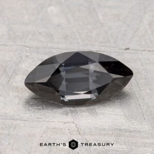 A 1.48-carat marquise-cut Spinel gemstone is displayed on a light textured surface with the text "EARTH'S TREASURY" at the bottom.
