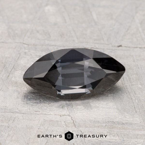 1.48-Carat Spinel A 1.48-carat marquise-cut Spinel gemstone is displayed on a light textured surface with the text "EARTH'S TREASURY" at the bottom.