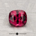 A 1.61-carat cushion-cut red Spinel is displayed on a light gray textured surface with "EARTH'S TREASURY" below.