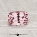 A 1.24-carat cushion-cut pink Spinel is displayed on a patterned gray surface, with the text "EARTH'S TREASURY" at the bottom of the image.