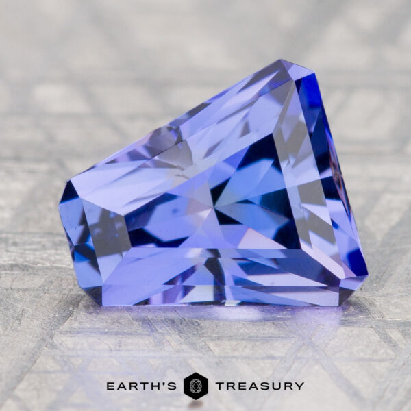 3.55-Carat Unheated Tanzanite (Zoisite) A 3.55-carat unheated tanzanite (zoisite) gemstone in blue-purple hues is displayed on a textured surface with "Earth's Treasury" beneath it.