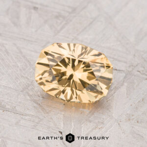 A 1.21-carat grossular garnet gemstone is shown on a textured gray background, with "Earth's Treasury" displayed at the bottom.