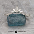 The Pave "Vilaine" band in 14K white gold, set with marquise-cut diamonds, rests on rough blue-green mineral atop a textured gray surface, displayed above the “EARTH’S TREASURY” logo.