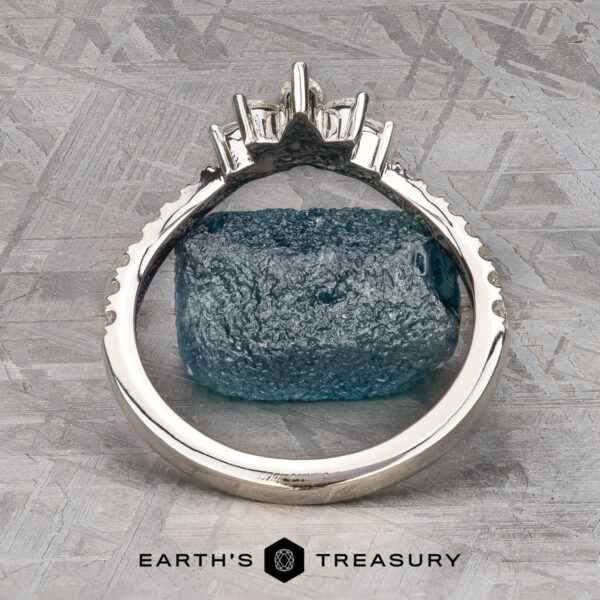 The Pave "Vilaine" band in 14K white gold The Pave "Vilaine" band in 14K white gold, set with marquise-cut diamonds, rests on rough blue-green mineral atop a textured gray surface, displayed above the “EARTH’S TREASURY” logo.