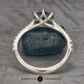 The Pave "Elenin" ring in platinum, featuring a 1.21-carat Montana sapphire, is displayed upright on a dark textured stone surface with the Earth's Treasury logo at the bottom.