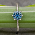 The Pave "Elenin" ring in platinum features a 1.21-carat Montana sapphire and sparkling pavé diamonds on the band, shown resting on a green leaf.