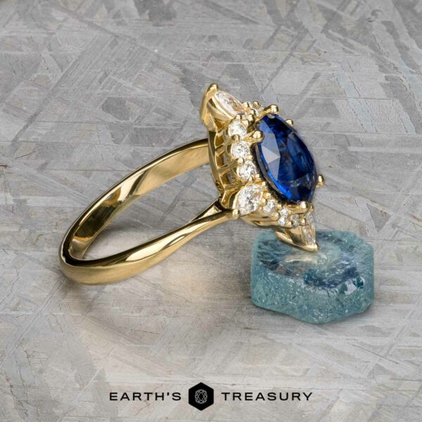 The "Francoise" ring in 18k yellow gold with 2.28-carat Ceylon sapphire The "Francoise" ring in 18k yellow gold features a 2.28-carat oval Ceylon sapphire and surrounding diamonds, displayed on a rough blue crystal with the "Earth's Treasury" logo below.