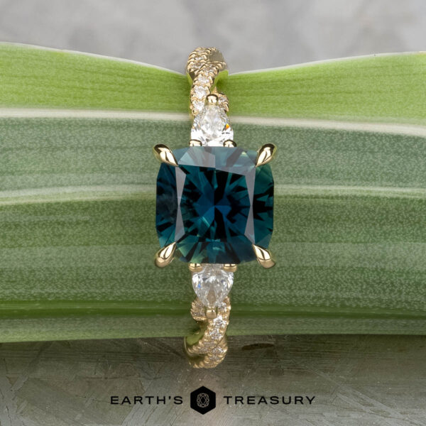 The "Lenore" ring in 14k yellow gold with 2.51-carat Australian sapphire The "Lenore" ring in 14k yellow gold features a 2.51-carat Australian sapphire and two pear-shaped side stones, shown on a green leaf background.