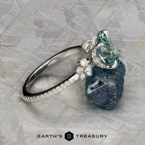 The Comet ring in platinum with 3.53-carat Montana sapphire The Comet ring in platinum features a 3.53-carat Montana sapphire and small diamonds, displayed on a dark mineral rock; the Earth's Treasury logo is at the bottom.