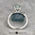 The Comet ring in platinum features a 3.53-carat Montana sapphire as its central stone, accented by smaller side stones, and is displayed upright on a textured stone background.