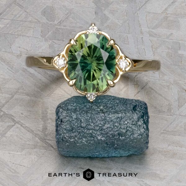 The "Marisol" ring in 14k yellow gold with 2.90-carat Australian sapphire The "Marisol" ring in 14k yellow gold, set with a 2.90-carat Australian sapphire, is displayed atop a rough blue stone on a textured gray background.
