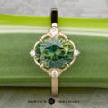 The "Marisol" ring in 14k yellow gold, featuring a 2.90-carat Australian sapphire and accent diamonds, is displayed on a green stem with the "Earth's Treasury" logo below.